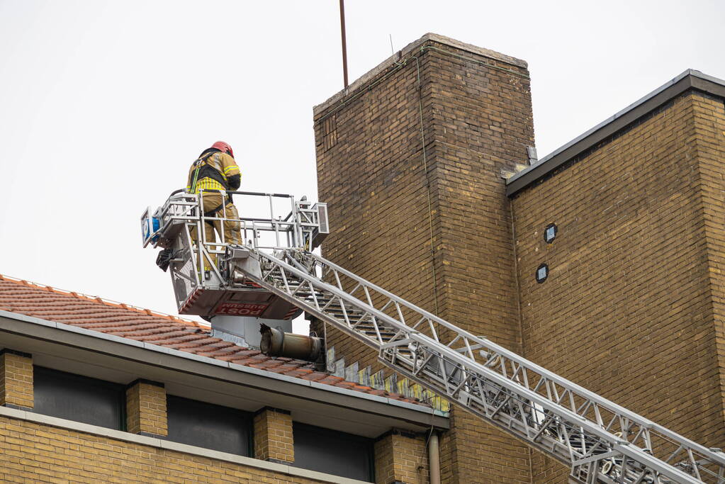 Schoorsteen breekt van leegstaand pand