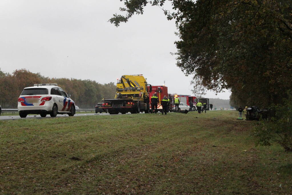 Auto zwaar beschadigd na botsing tegen boom langs snelweg