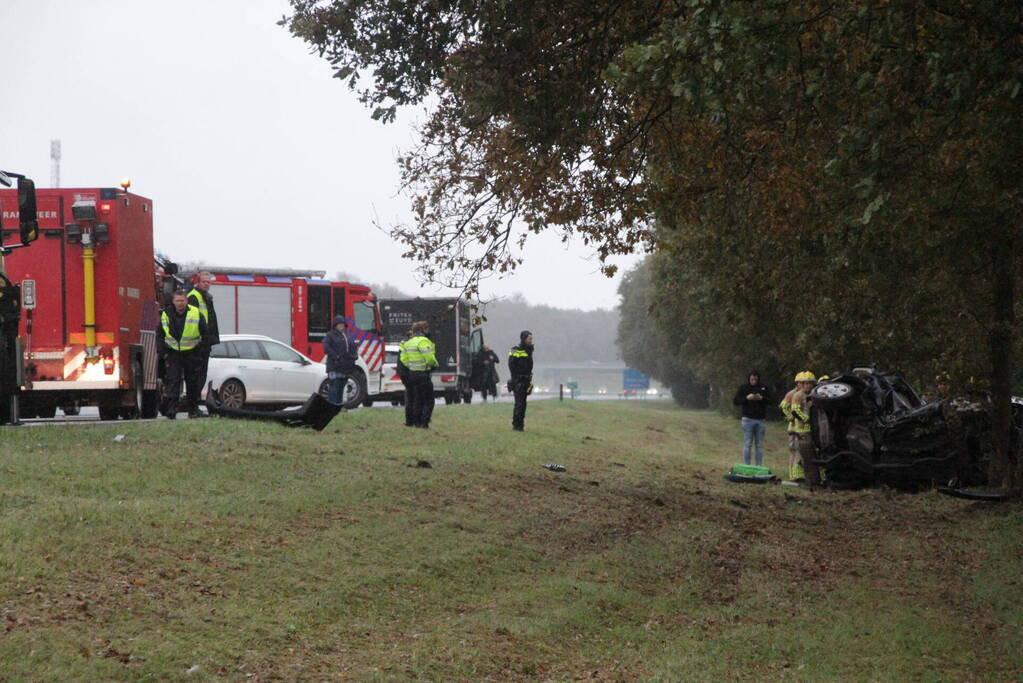 Auto zwaar beschadigd na botsing tegen boom langs snelweg