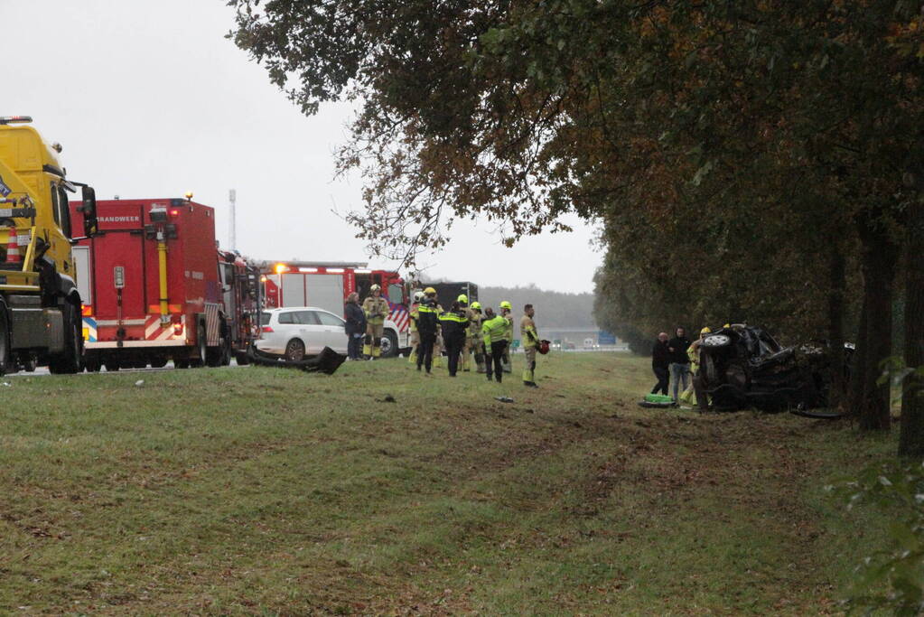 Auto zwaar beschadigd na botsing tegen boom langs snelweg