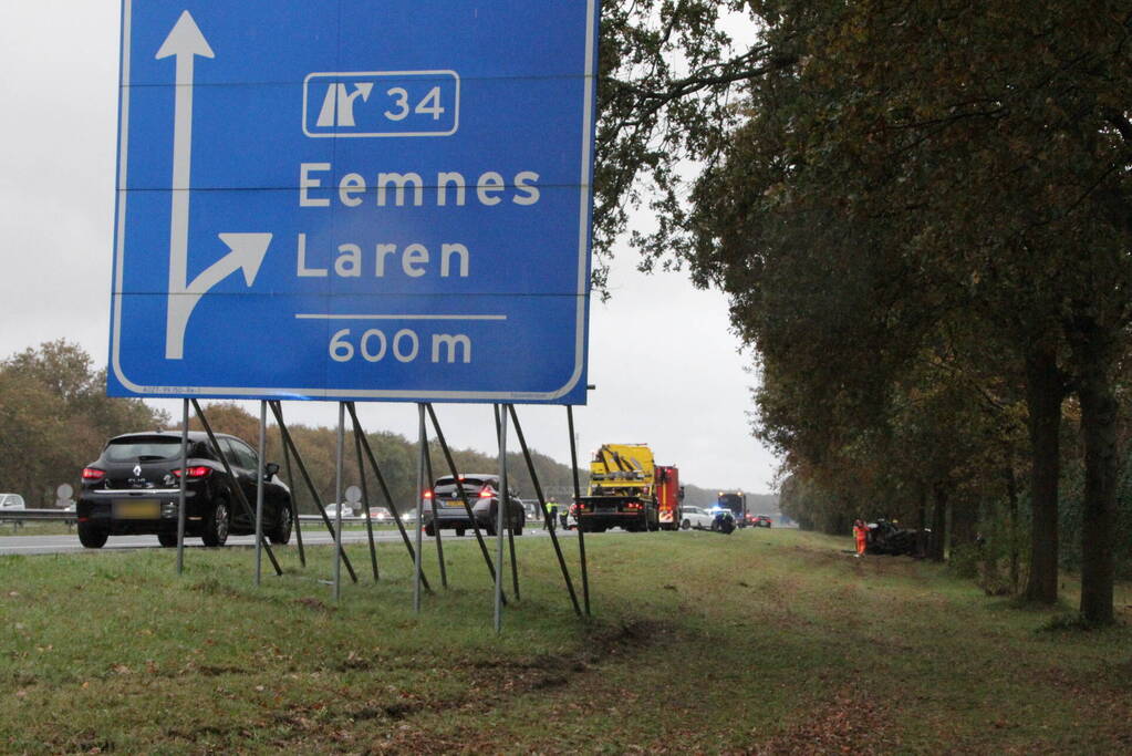 Auto zwaar beschadigd na botsing tegen boom langs snelweg