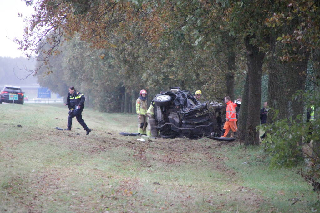 Auto zwaar beschadigd na botsing tegen boom langs snelweg