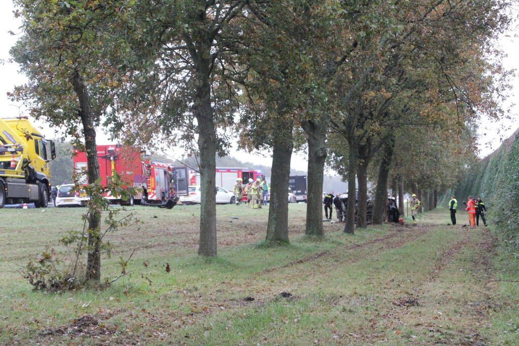 Auto zwaar beschadigd na botsing tegen boom langs snelweg