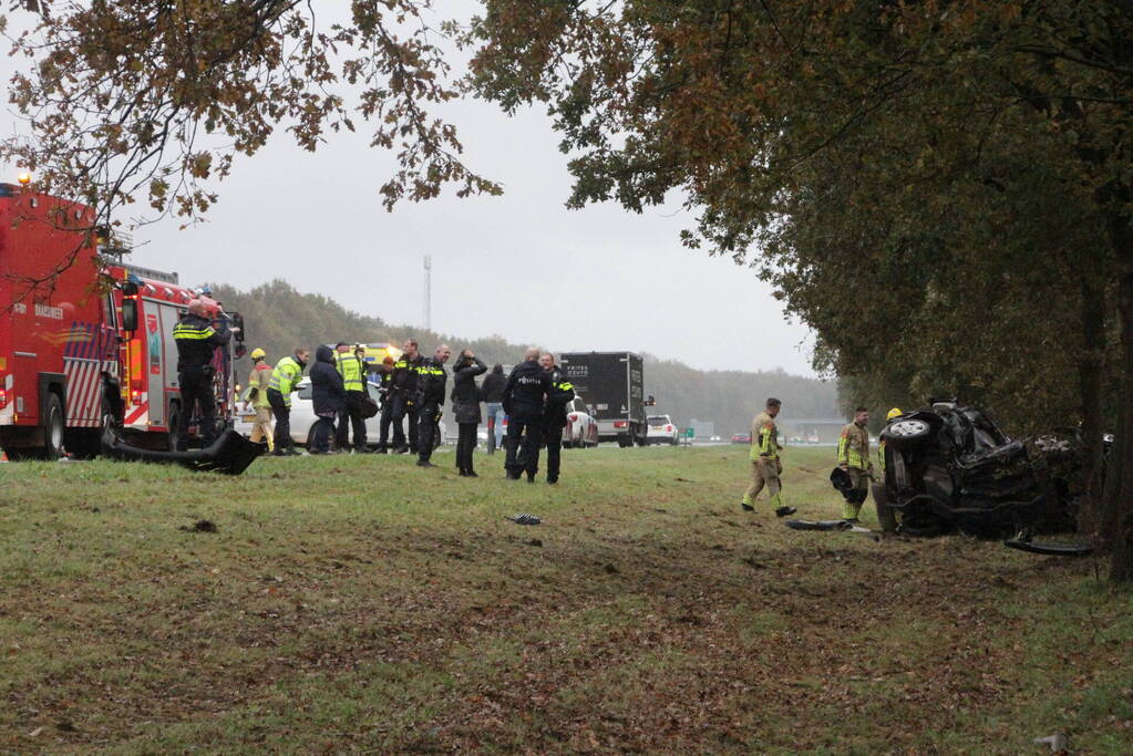 Auto zwaar beschadigd na botsing tegen boom langs snelweg
