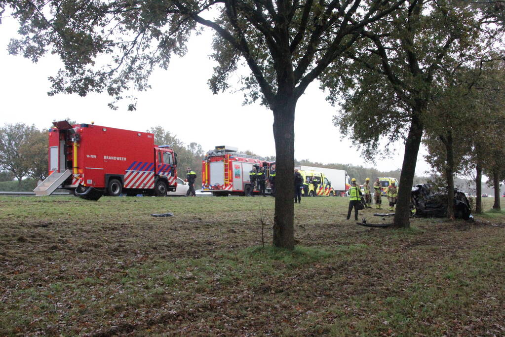 Auto zwaar beschadigd na botsing tegen boom langs snelweg