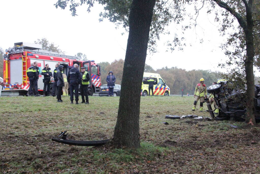Auto zwaar beschadigd na botsing tegen boom langs snelweg