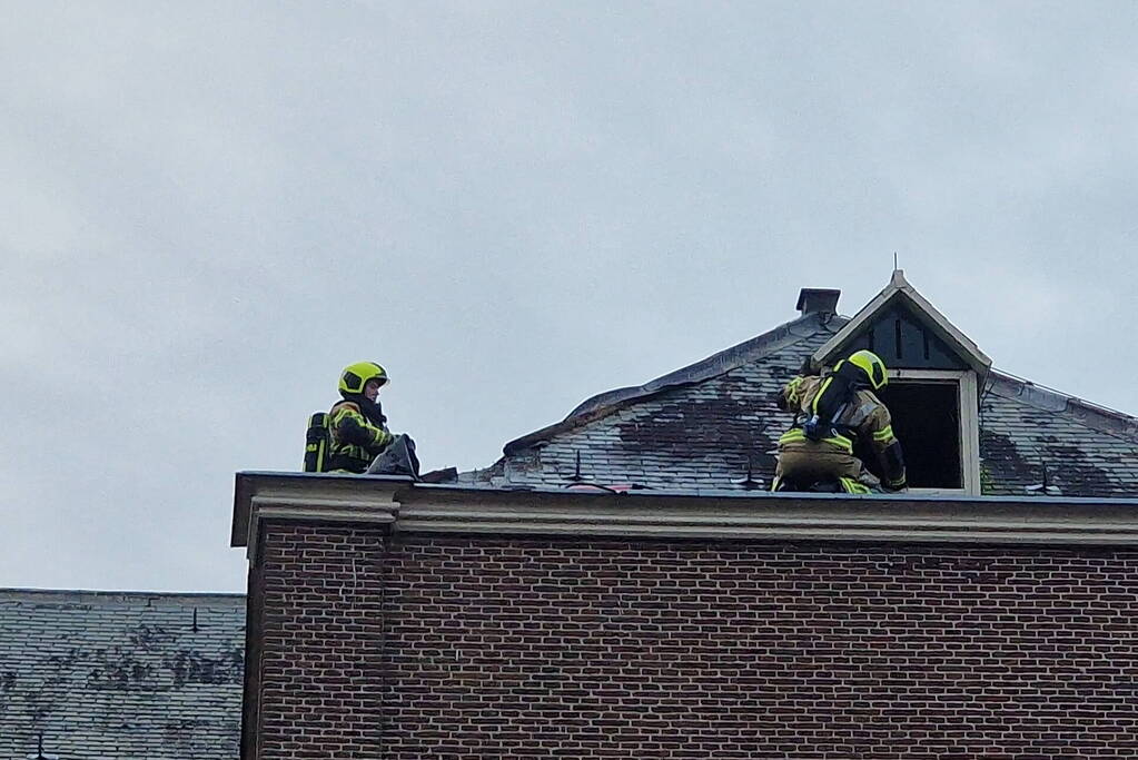 Brandweer blust brand op dak van Kapel