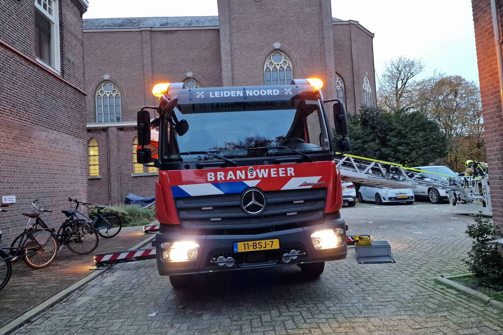 Brandweer blust brand op dak van Kapel