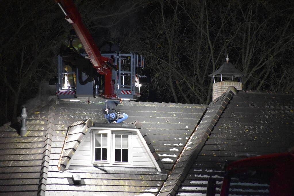 Persoon op dak van woning