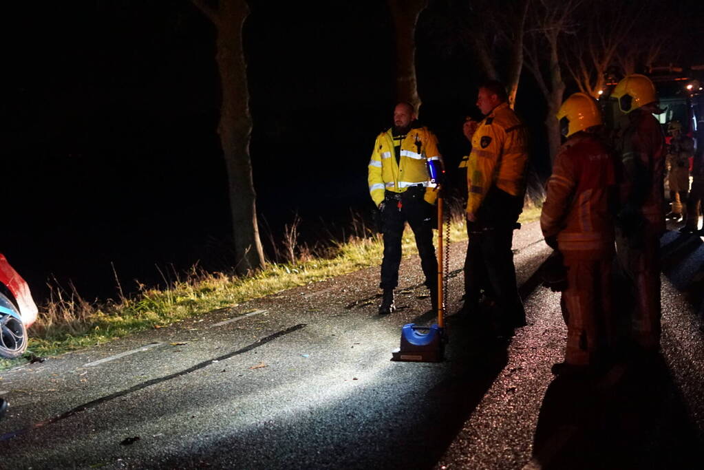 Auto zwaar beschadigd na frontale botsing tegen boom, bestuurder zwaargewond