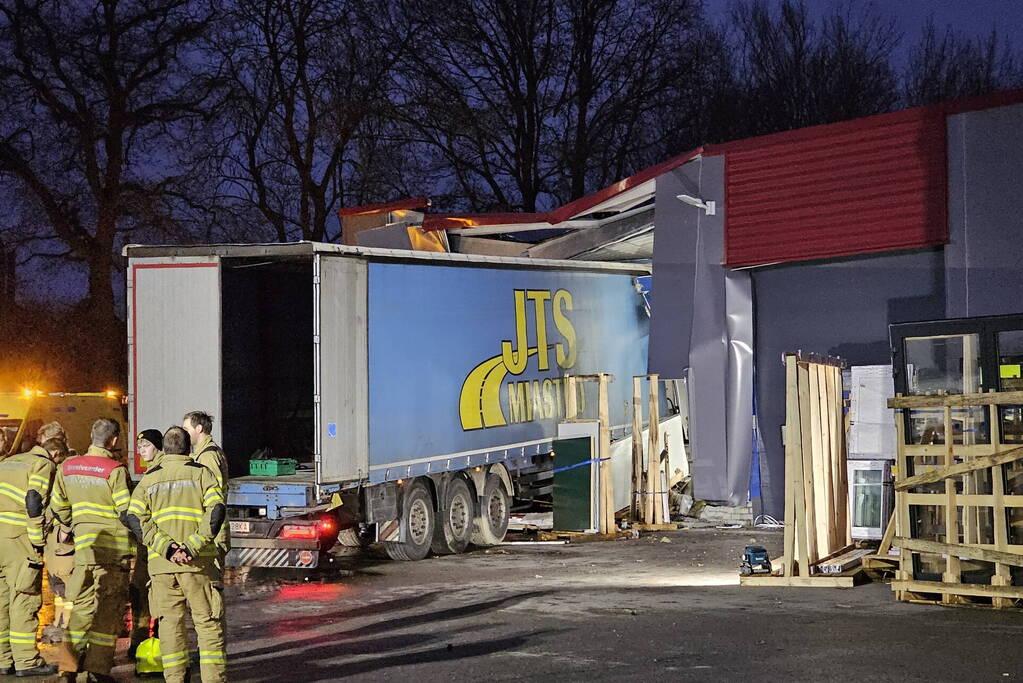 Truck met oplegger rijdt bedrijfspand binnen