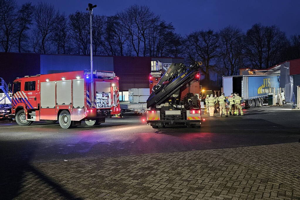 Truck met oplegger rijdt bedrijfspand binnen