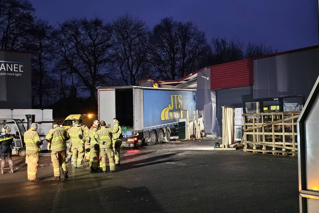 Truck met oplegger rijdt bedrijfspand binnen