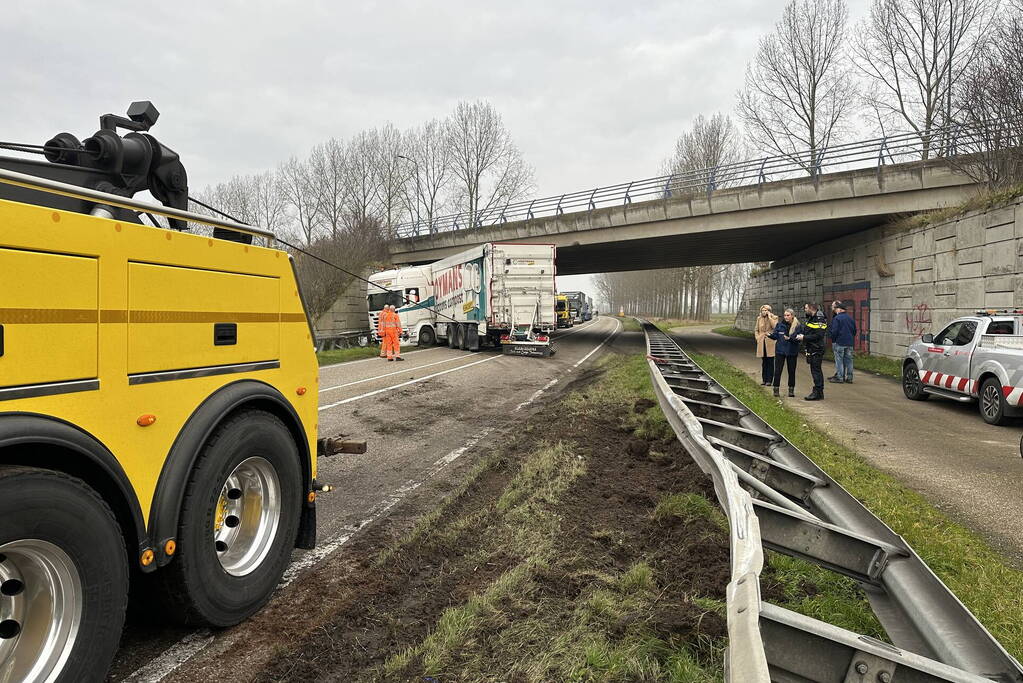 Vrachtwagen schaart en botst tegen viaduct