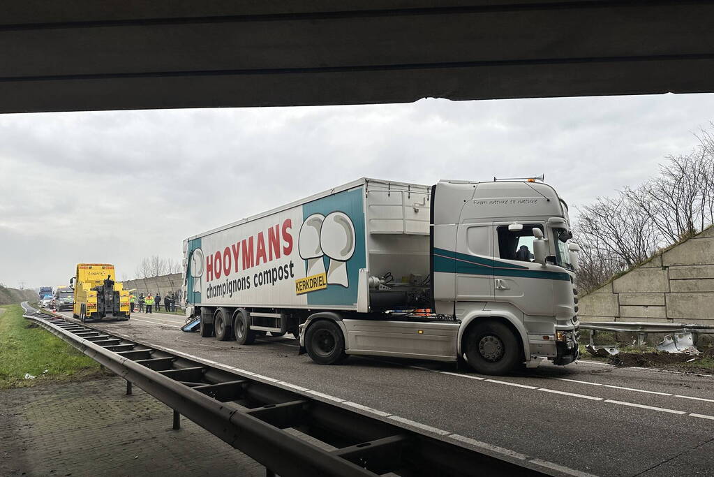 Vrachtwagen schaart en botst tegen viaduct