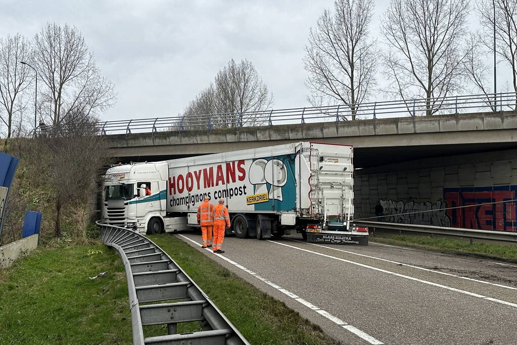 Vrachtwagen schaart en botst tegen viaduct