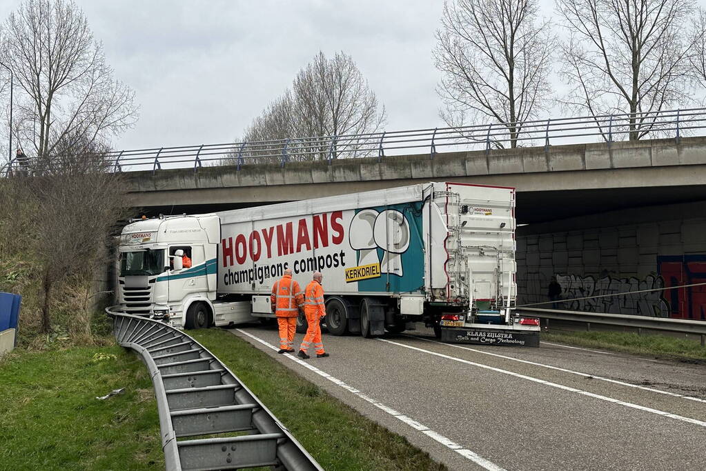 Vrachtwagen schaart en botst tegen viaduct