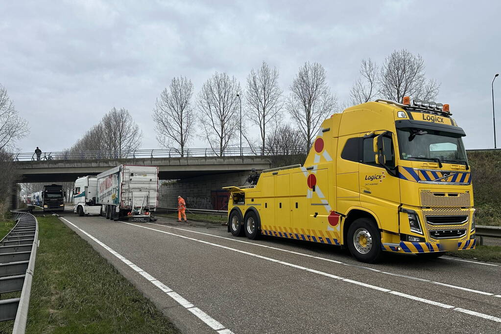 Vrachtwagen schaart en botst tegen viaduct