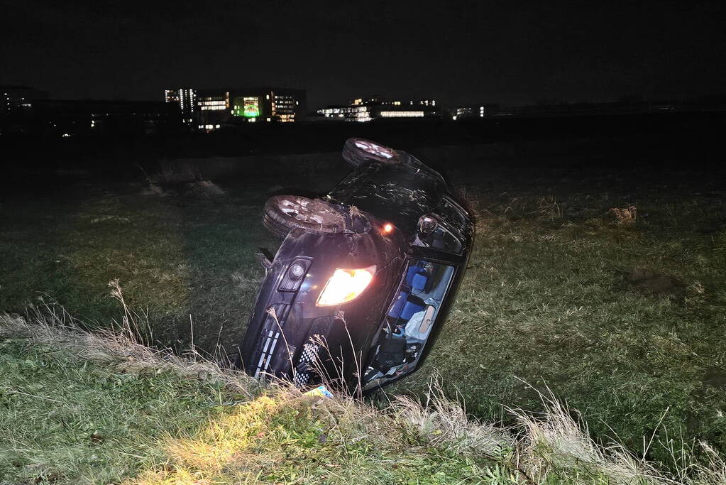 Auto belandt op zijkant in sloot na botsing met vrachtwagen