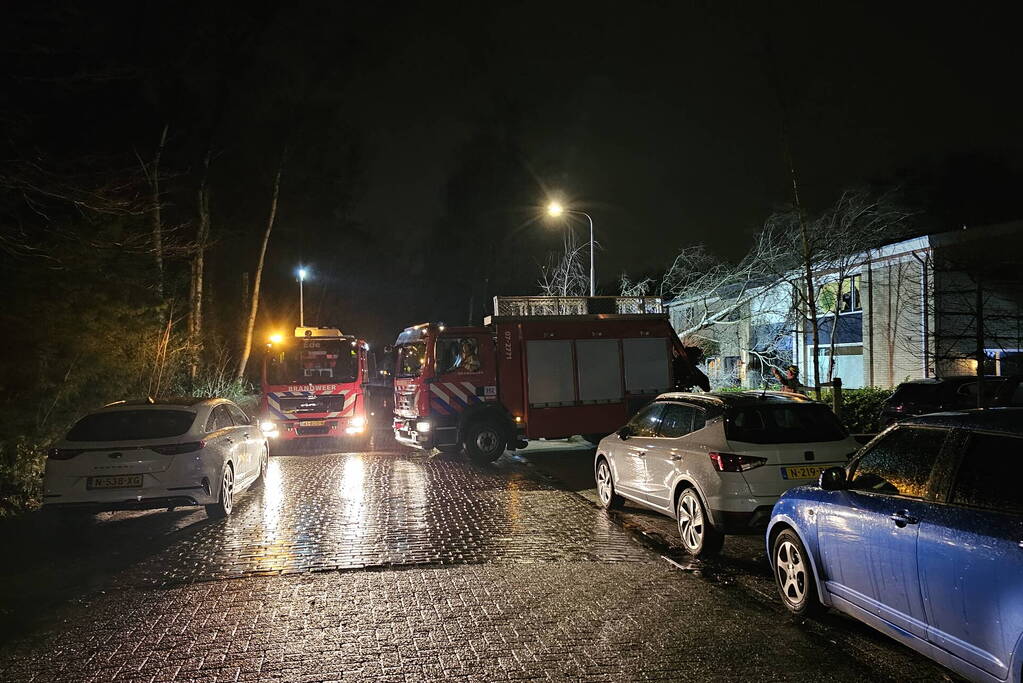 Grote boom waait om en belandt tegen woning