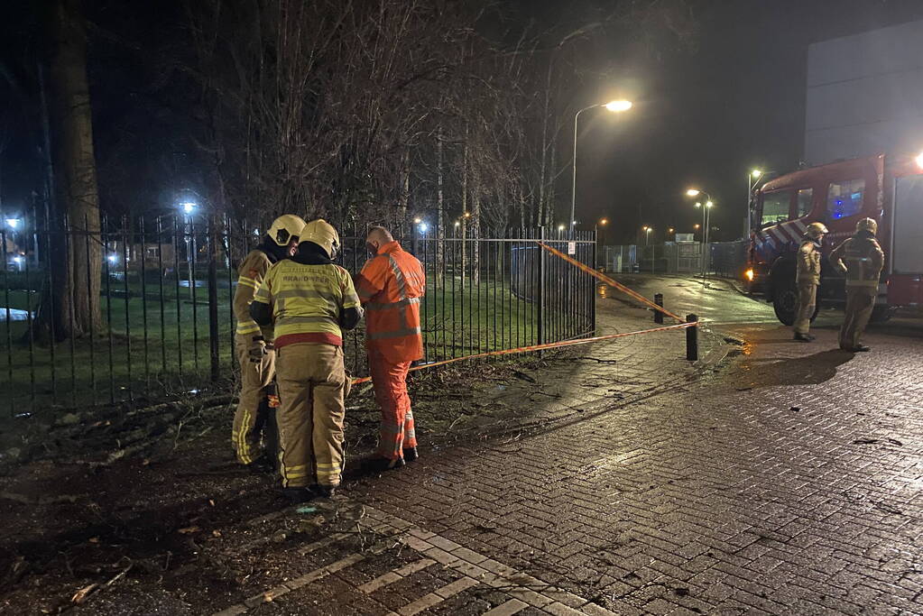 Omgevallen boom valt op hekwerk en blokkeert weg
