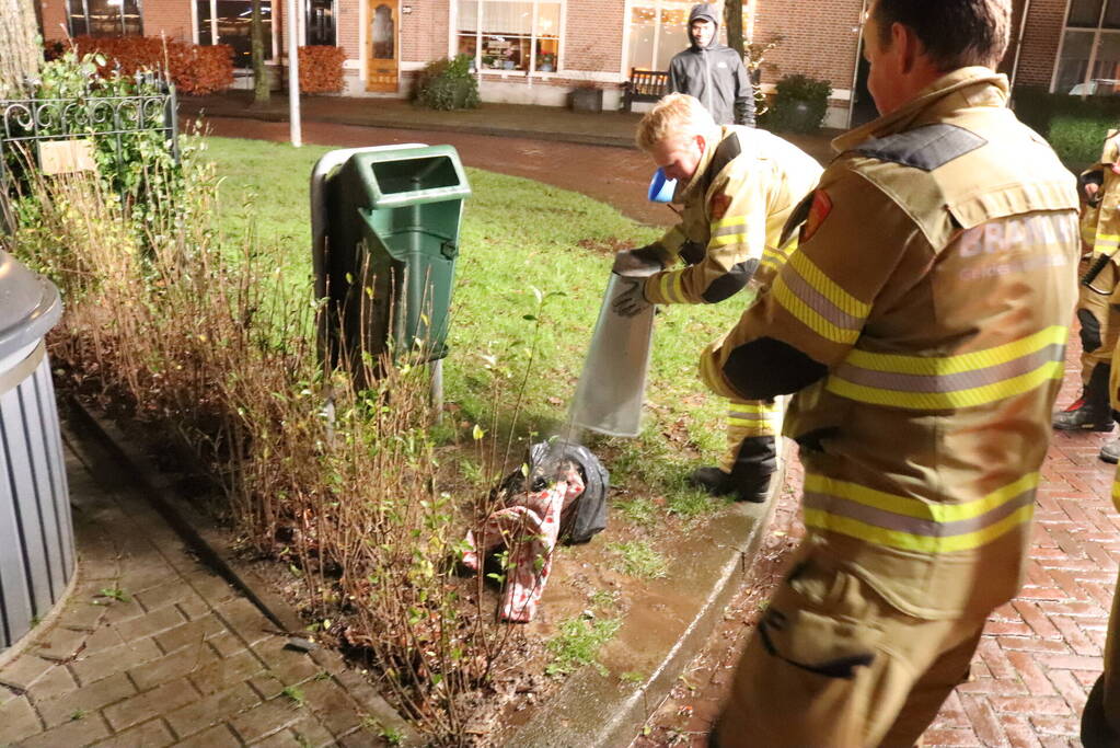 Brandweer blust brand in prullenbak