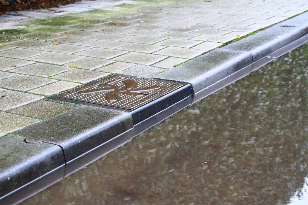 Straat onder water na overstroming riool