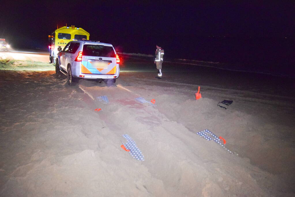 Politiejeep muurvast in los zand op strand