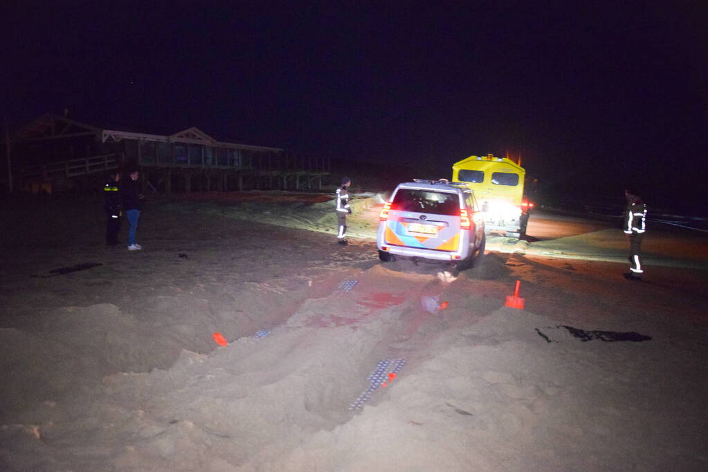 Politiejeep muurvast in los zand op strand