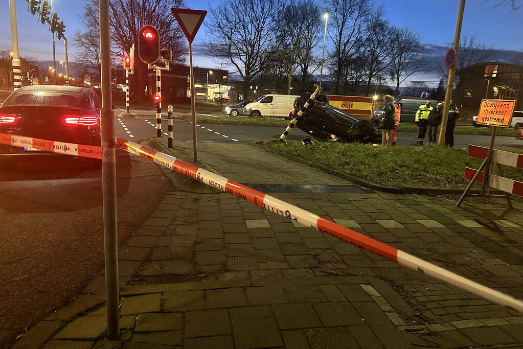 Auto knalt op verkeerslichten en slaat over de kop