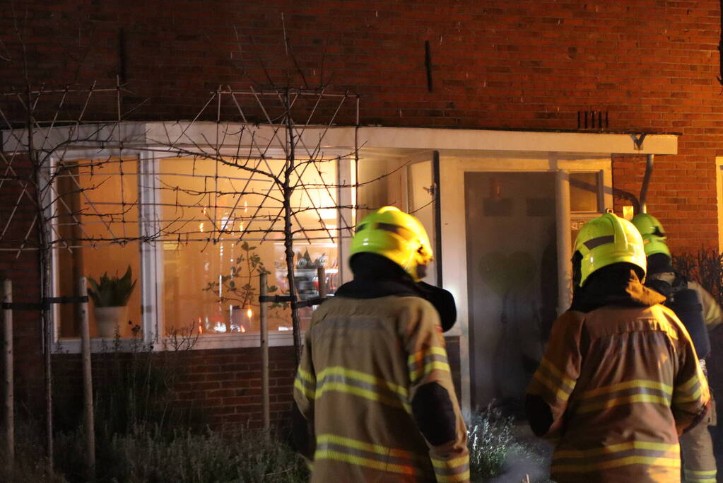 Rook in woning door smeulend hout op kachel