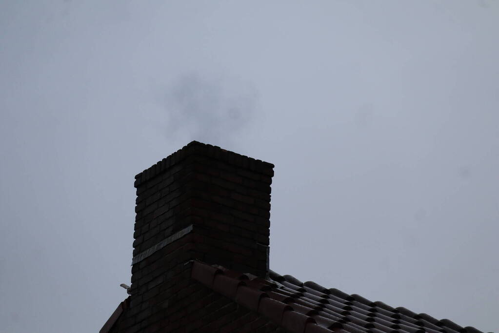 Brandweer veegt schoorsteen na brand