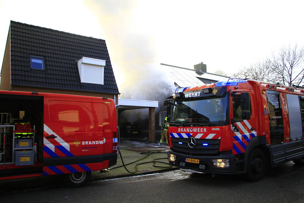 Personenauto vat vlam onder carport