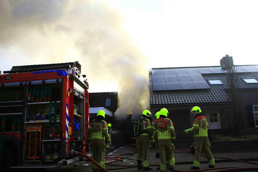 Personenauto vat vlam onder carport