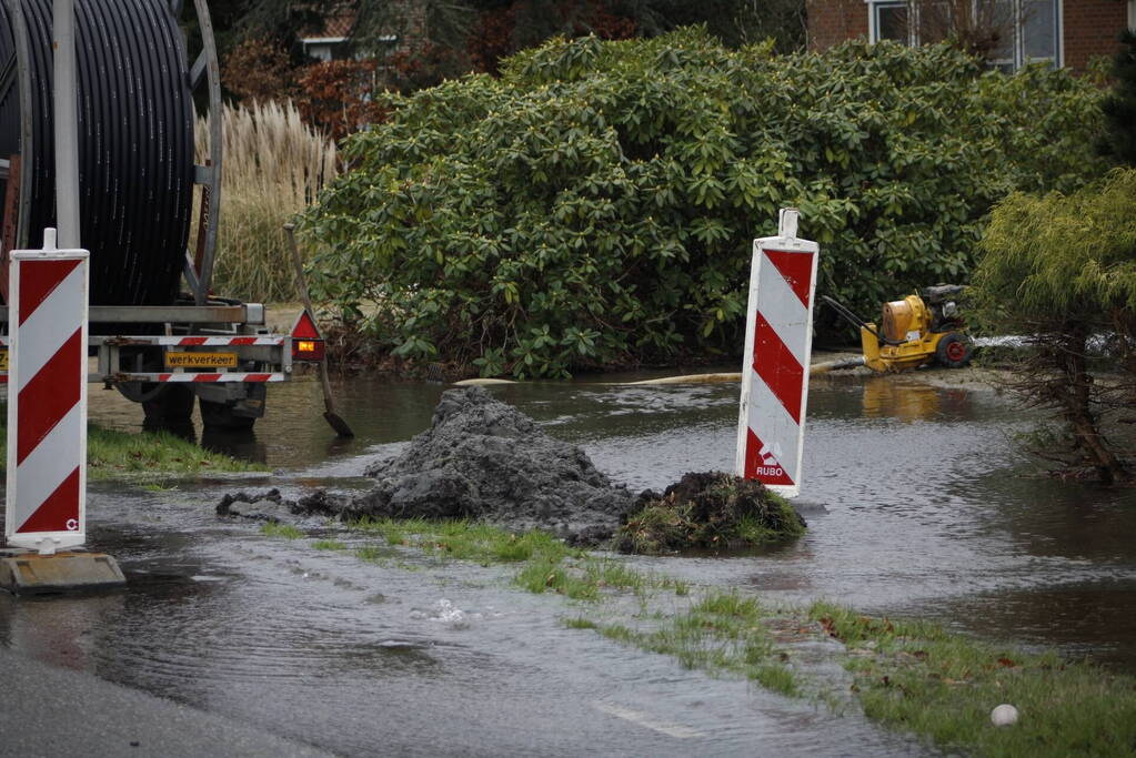 Straat onder water gelopen door kapotte waterleiding