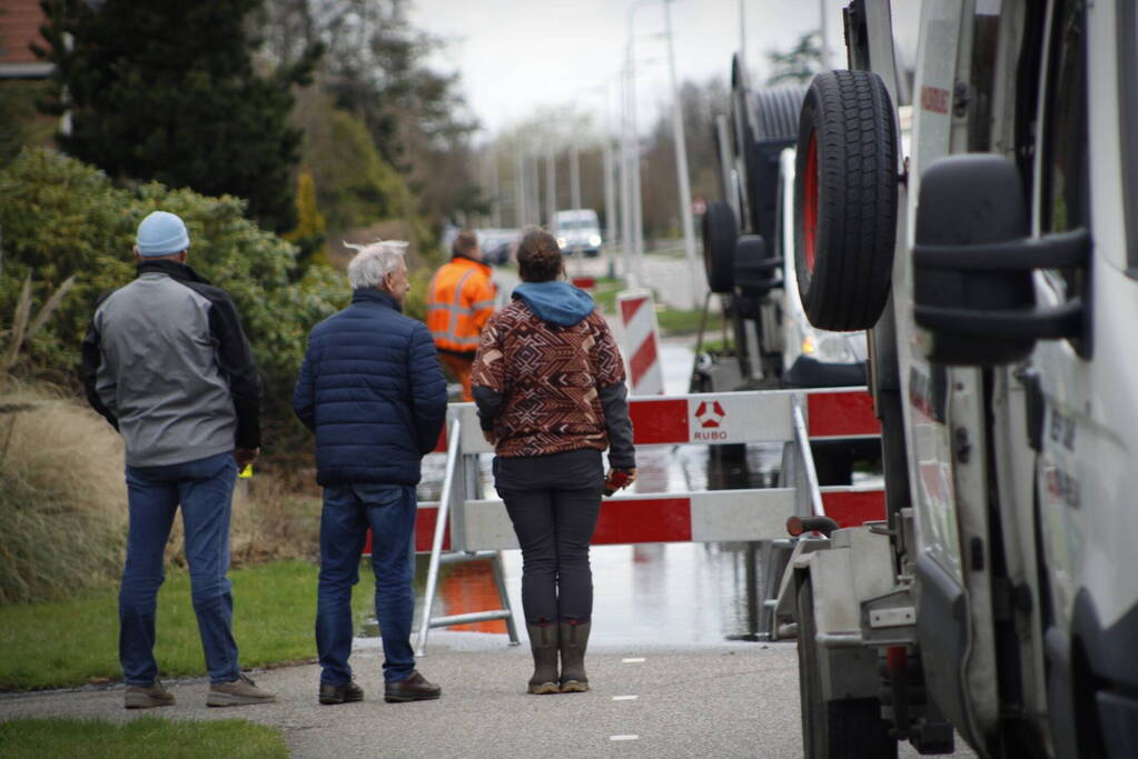 Straat onder water gelopen door kapotte waterleiding