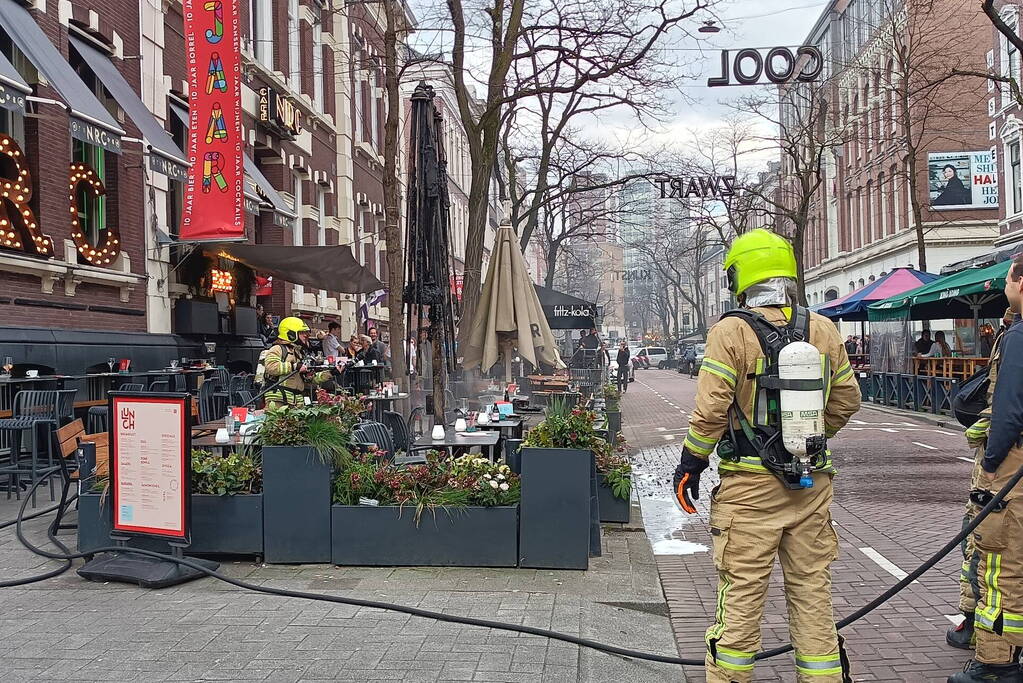 Parasol vat vlam op terras van café