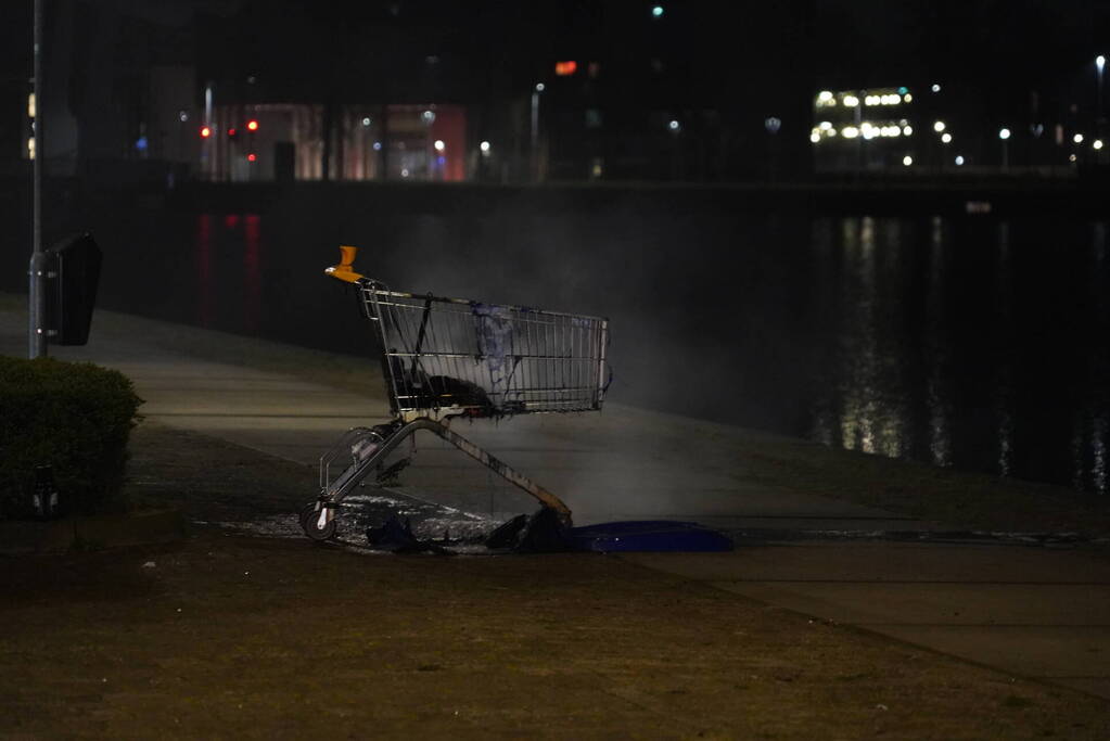 Winkelwagen met afval bij daklozenopvang in brand gestoken