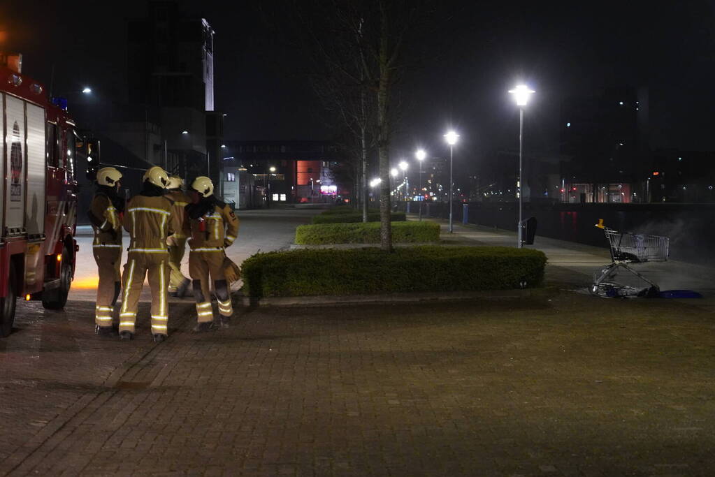 Winkelwagen met afval bij daklozenopvang in brand gestoken