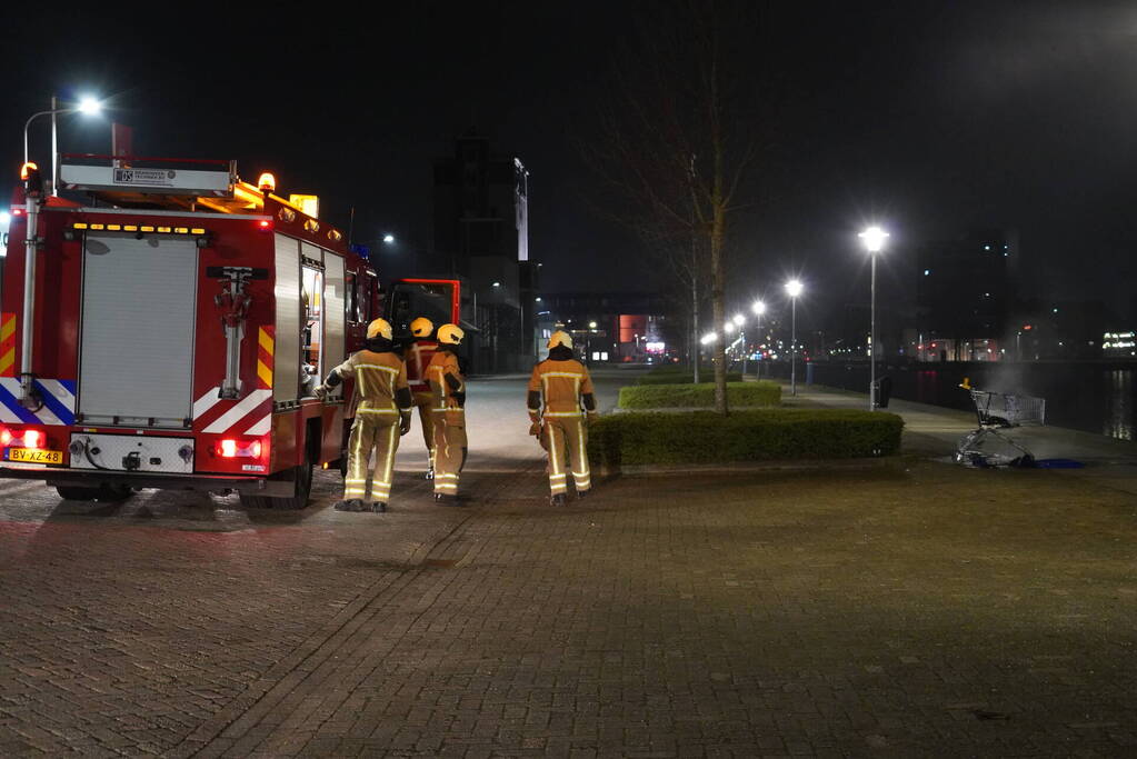 Winkelwagen met afval bij daklozenopvang in brand gestoken