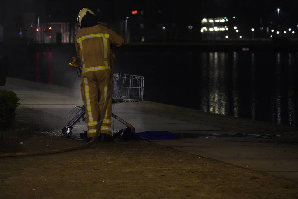 Winkelwagen met afval bij daklozenopvang in brand gestoken