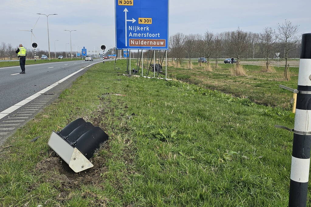 Auto ramt verkeerslicht en belandt op zijn zij in een greppel