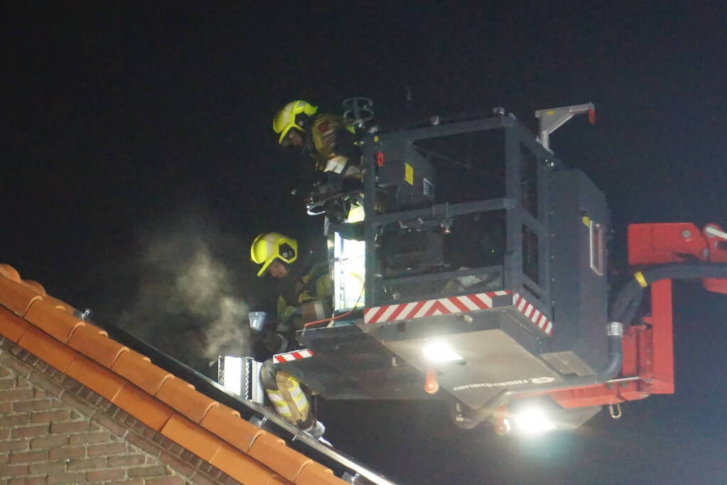 Brandweer veegt schoorsteen na brand