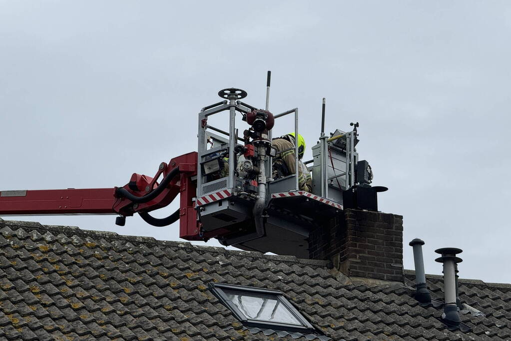 Brandweer veegt schoorsteen na brand