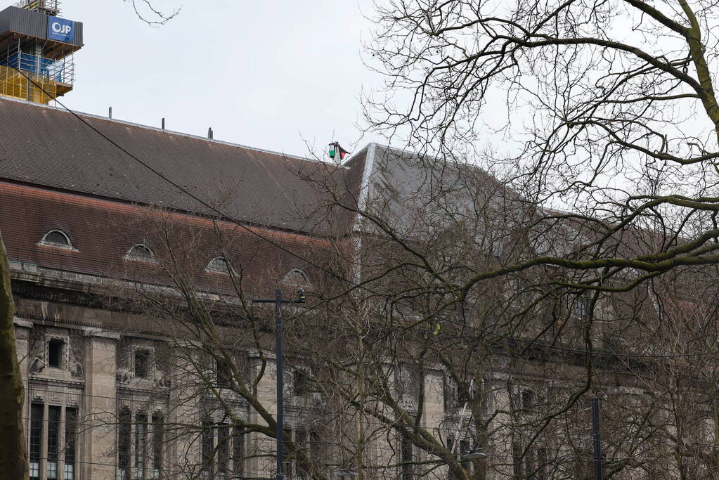 Demonstrant klimt op gebouw naast gemeentehuis