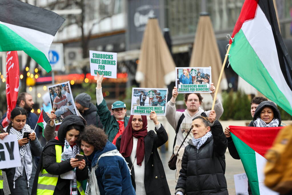 Demonstrant klimt op gebouw naast gemeentehuis
