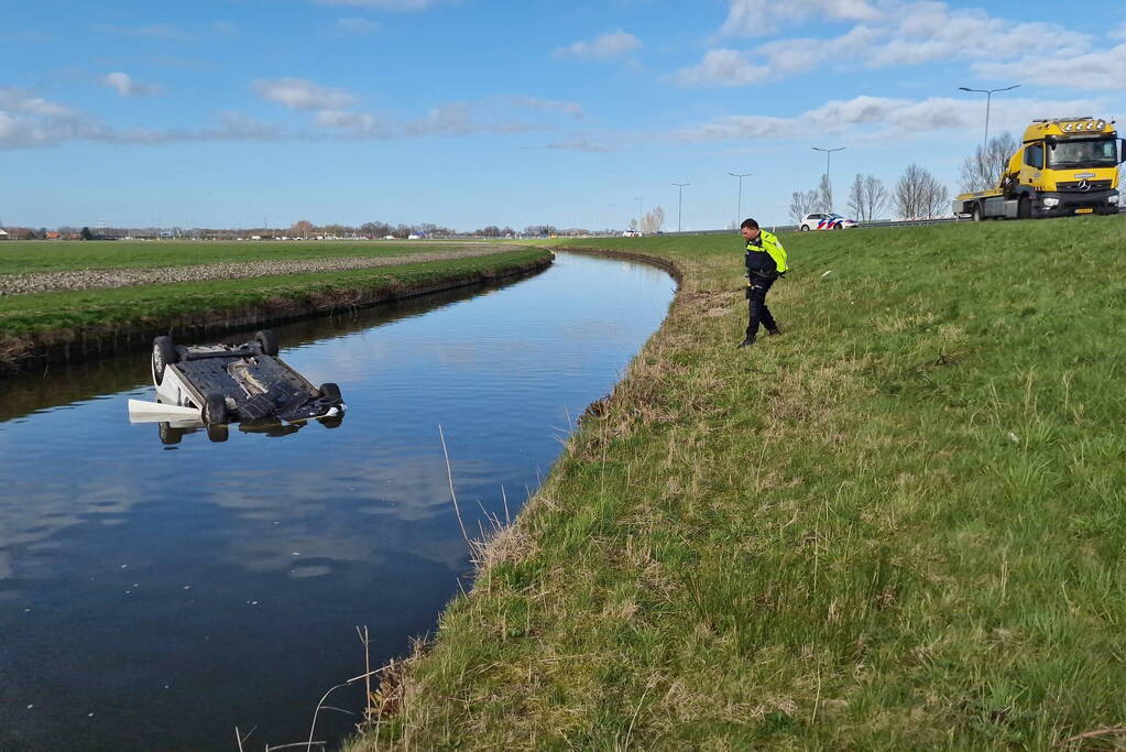 Auto te water langs, bestuurder naar ziekenhuis