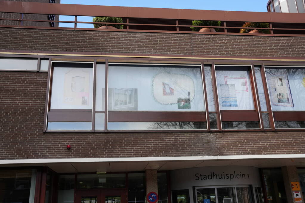 Tekeningen, foto's en bouwtekeningen als raamkunstwerk bij stadshuis