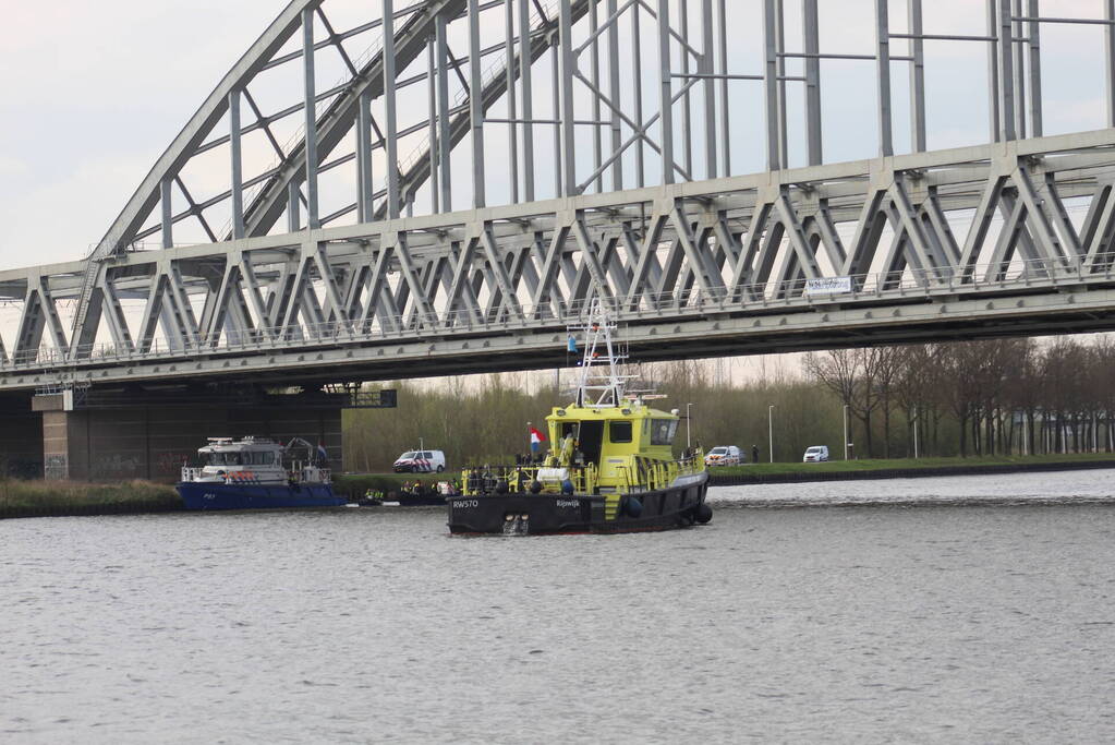 Persoon op bogen van brug, vele hulpdiensten aanwezig