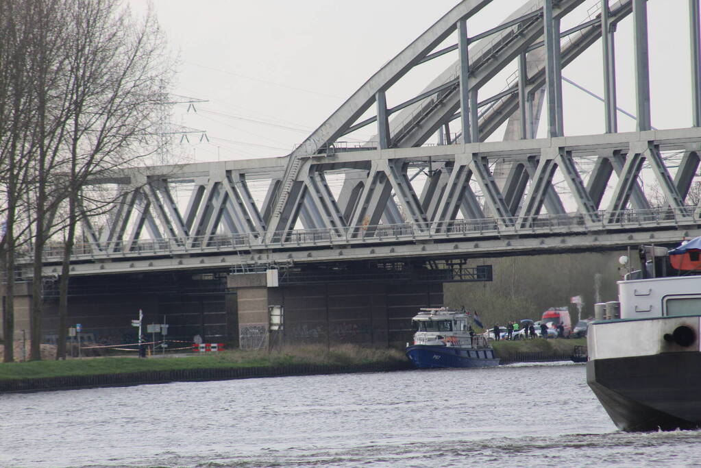 Persoon op bogen van brug, vele hulpdiensten aanwezig